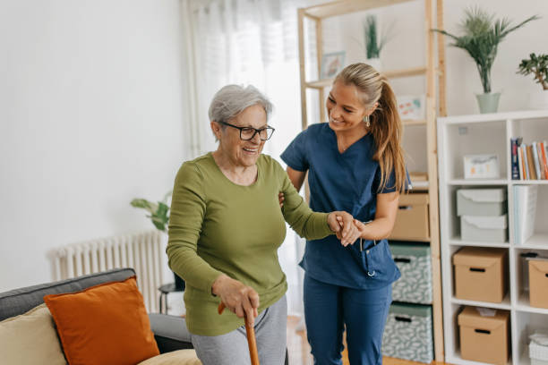Caregiver helping elderly woman with walking